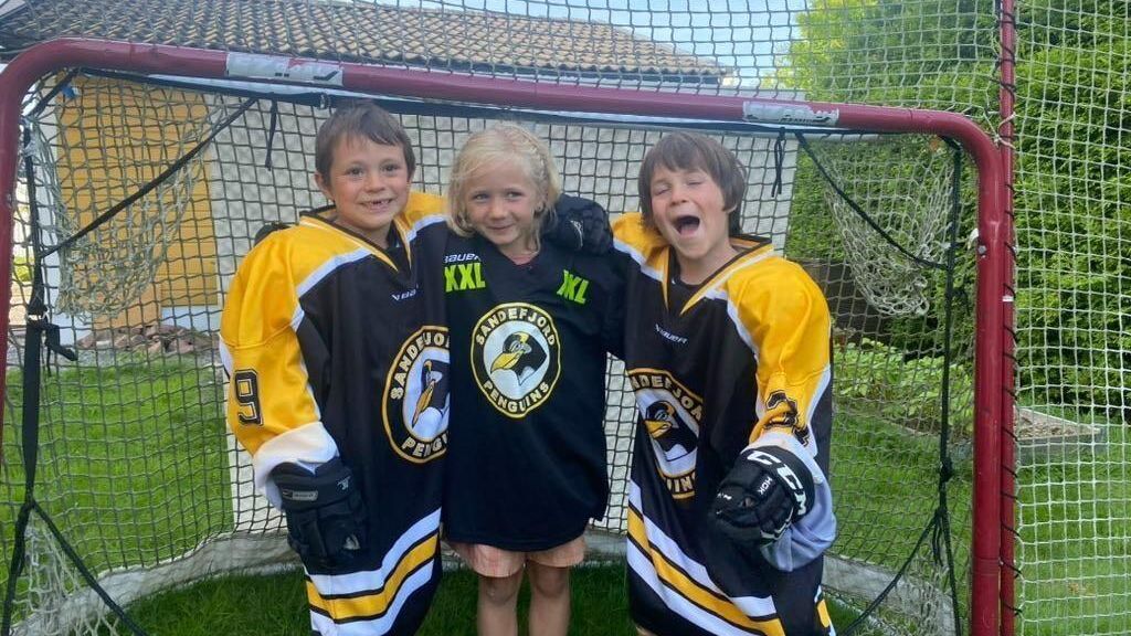 3 barn foran et hockeymål
